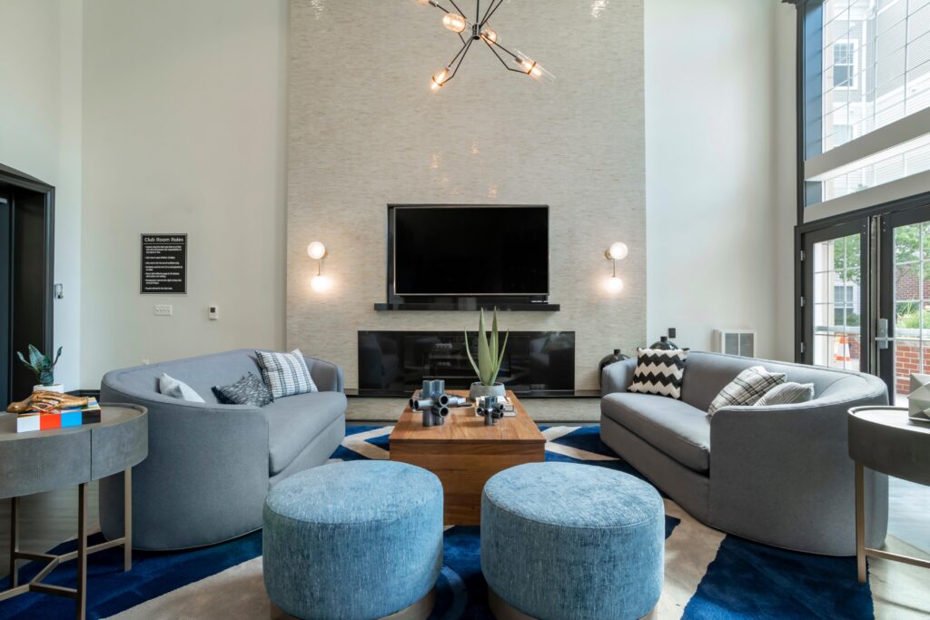 clubhouse room with couches, tables, fireplace, and a big TV. Club room rules on wall, see long description.