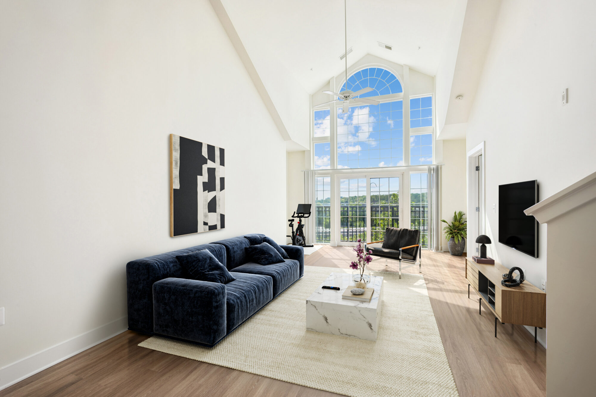 Bell Arlington Ridge living room layout with a couch and coffee table next to floor-to-ceiling windows.