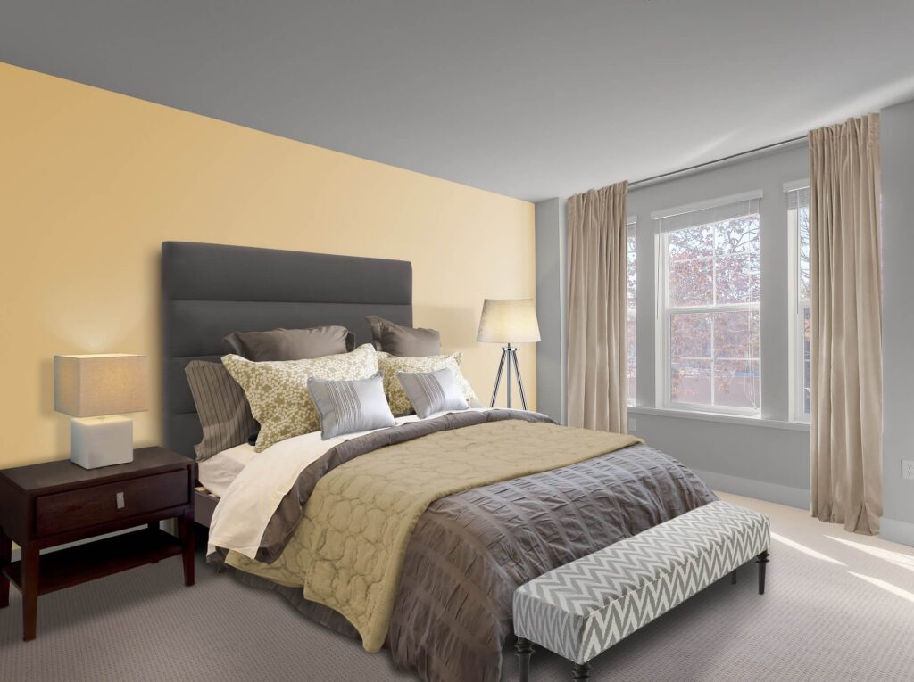A cozy bedroom with a large bed, multiple pillows, beige and gray bedding, a nightstand with a lamp, a floor lamp, beige curtains, and a window letting in natural light.